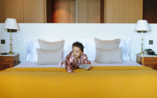 Baby crawling on a yellow bed.