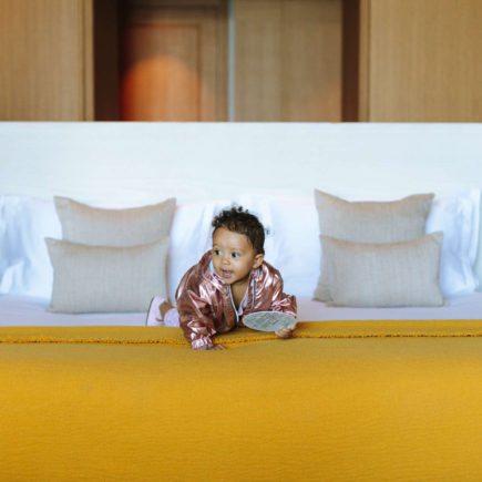 Baby crawling on a yellow bed.