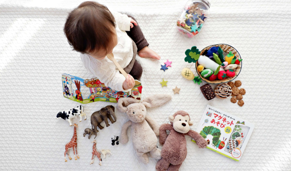 A baby is sitting on the floor surrounded by toys.